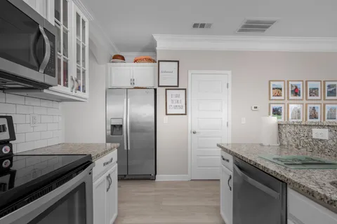 a kitchen with stainless steel appliances granite countertop a refrigerator a stove and a sink with wooden floor