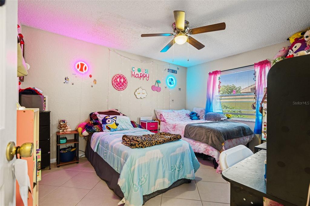 12292 Ronald Street Spring Hill, FL 34609 - Photo 7 of 18 a bedroom with a bed and a chandelier