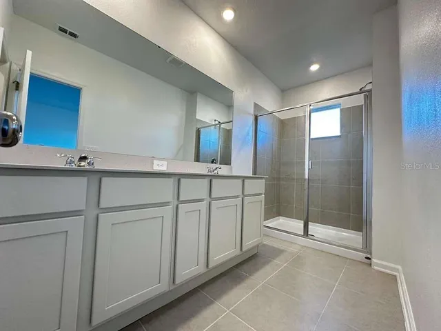 a bathroom with a shower sink and mirror