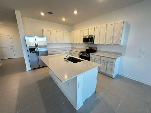 a kitchen that has a sink and a stove in it