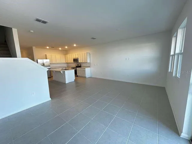 a view of a kitchen with kitchen island and stainless steel appliances