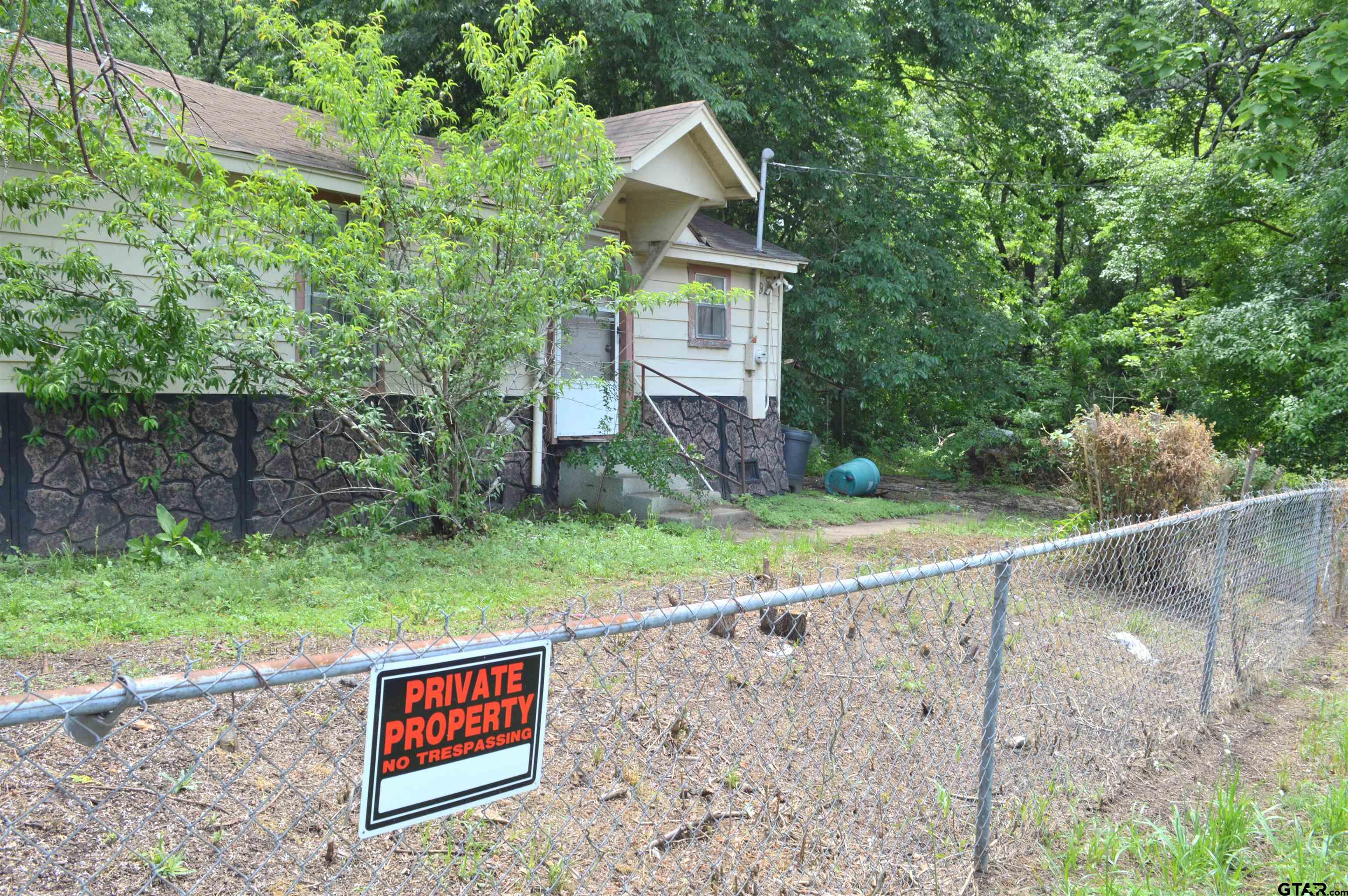 3210 Bellwood Road Tyler, TX 75701 - Photo 3 of 18 a view of a wooden house with a yard and large trees