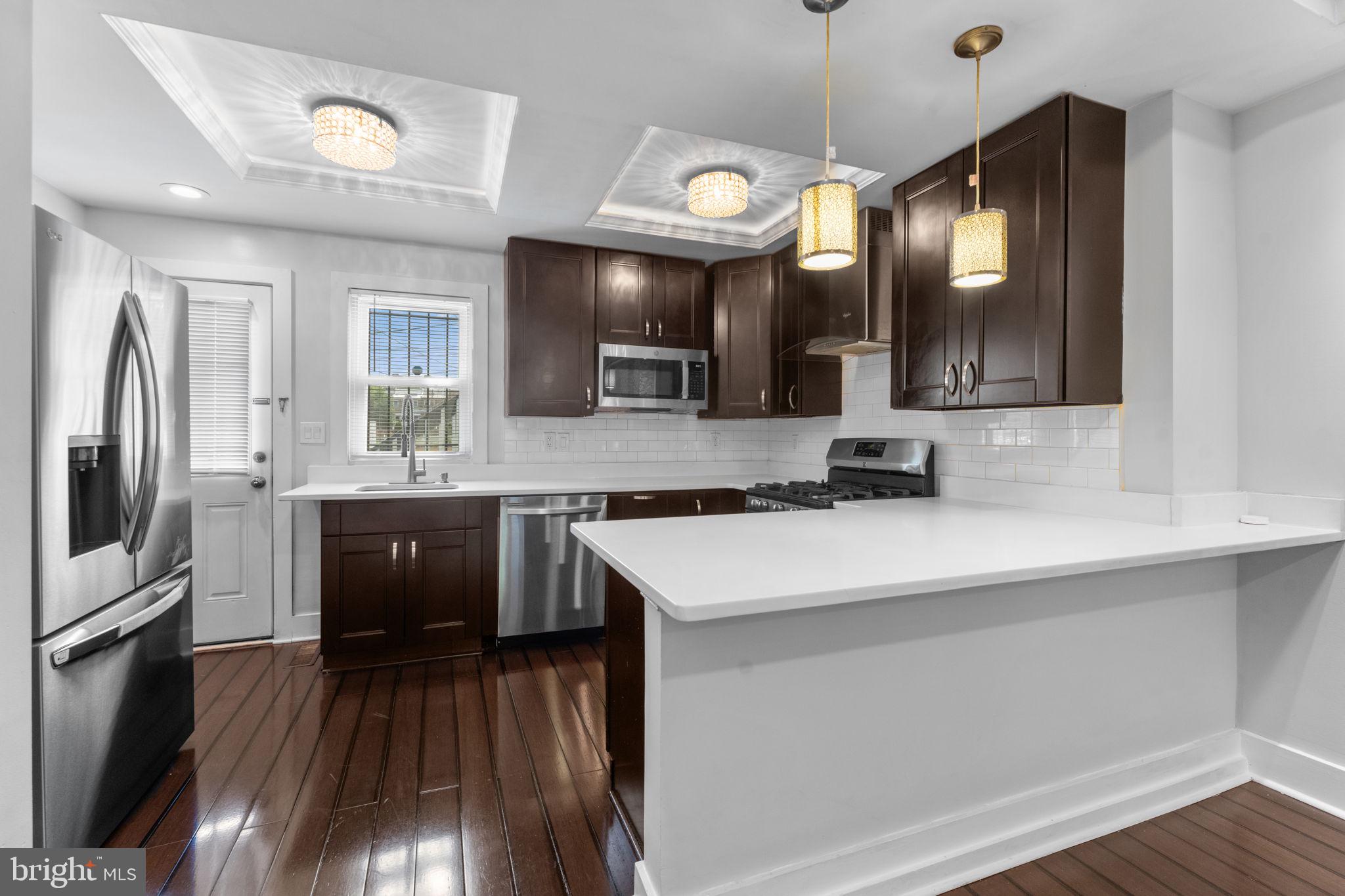 5209 5th Street Northwest Washington, DC 20011 - Photo 11 of 47 a large kitchen with a sink and dishwasher a refrigerator with wooden floor