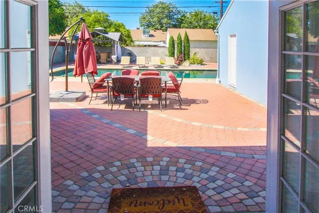 a view of a patio with dining table and chairs with wooden floor