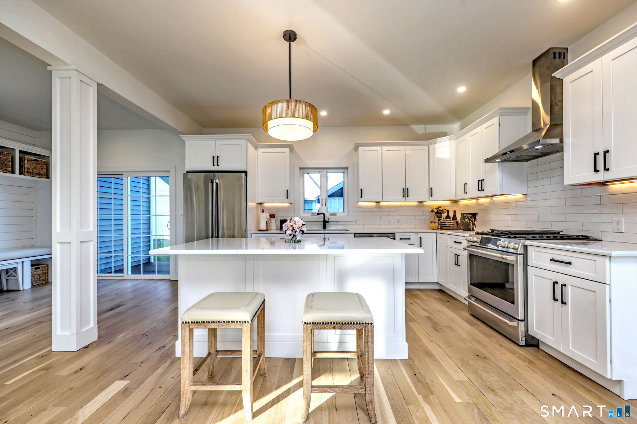 12 Usher Street Milford, CT 06460 - Photo 14 of 46 a kitchen with stainless steel appliances a dining table chairs stove and refrigerator