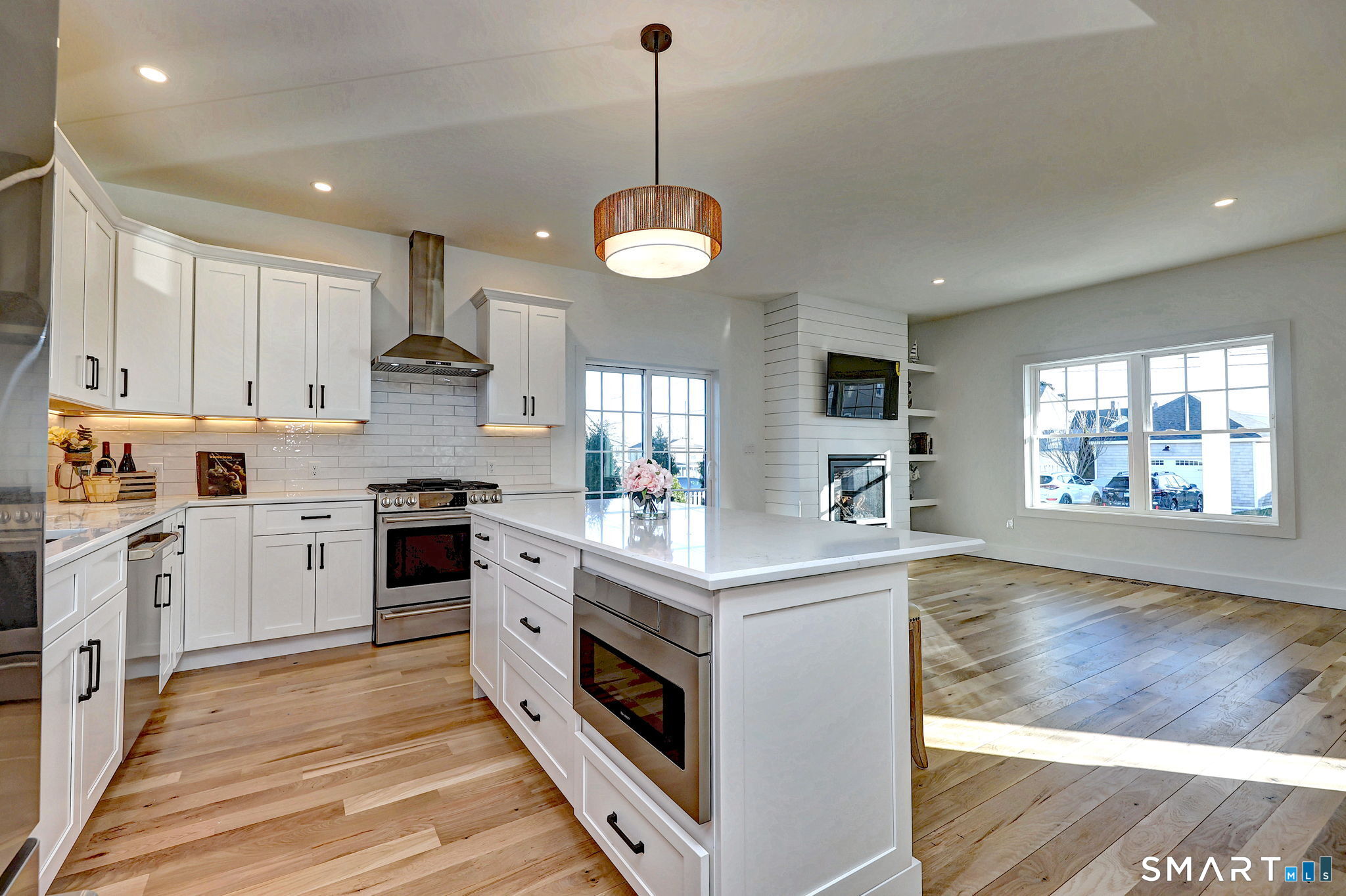 12 Usher Street Milford, CT 06460 - Photo 15 of 46 a kitchen with stainless steel appliances granite countertop a stove a sink dishwasher a refrigerator and white cabinets with wooden floor