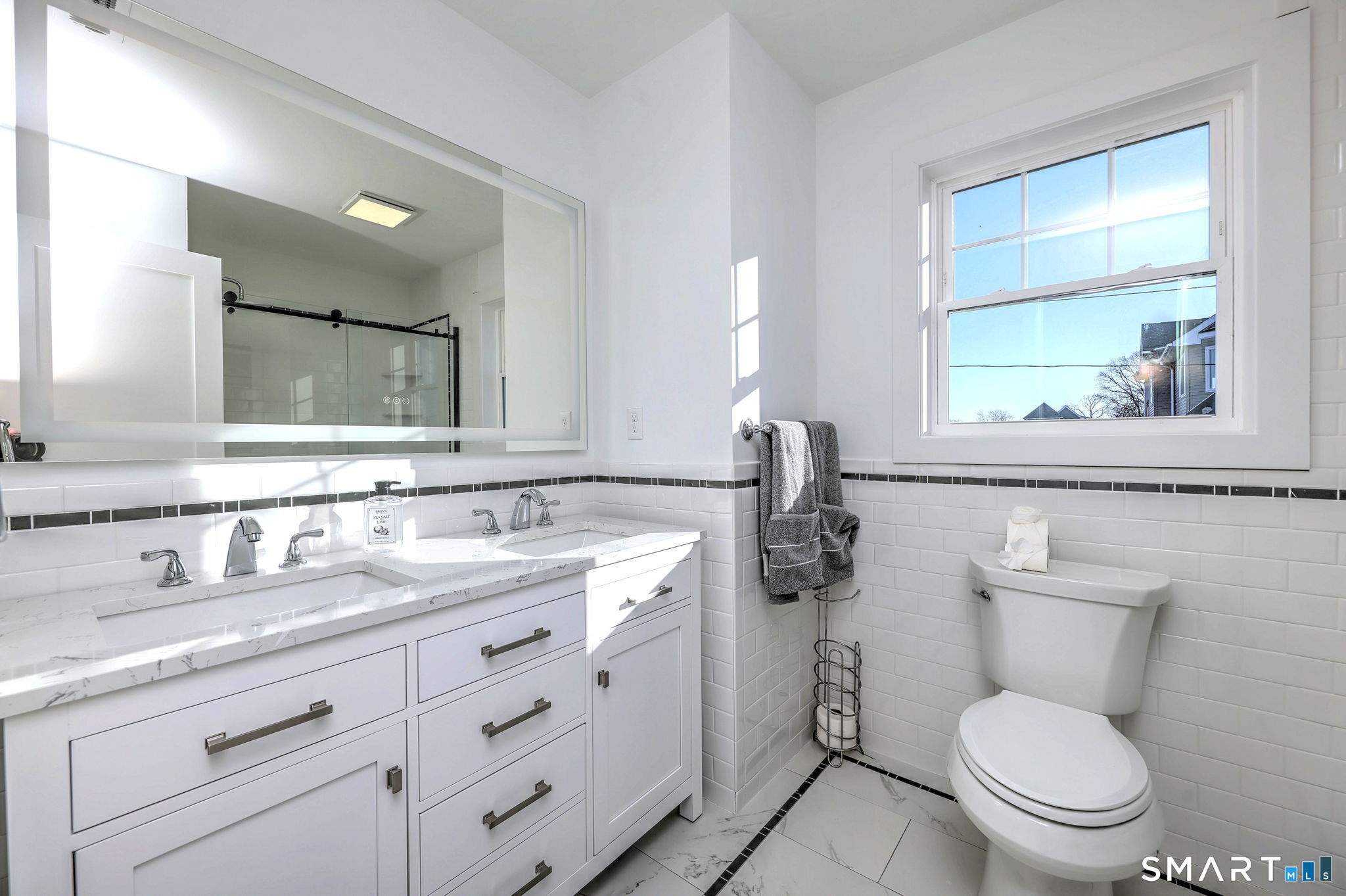 12 Usher Street Milford, CT 06460 - Photo 34 of 46 a bathroom with a granite countertop toilet a sink a mirror and a window