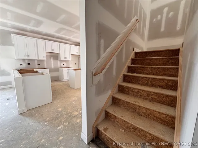 a view of an empty room with wooden stairs