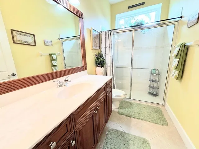 a bathroom with a granite countertop sink a mirror and shower