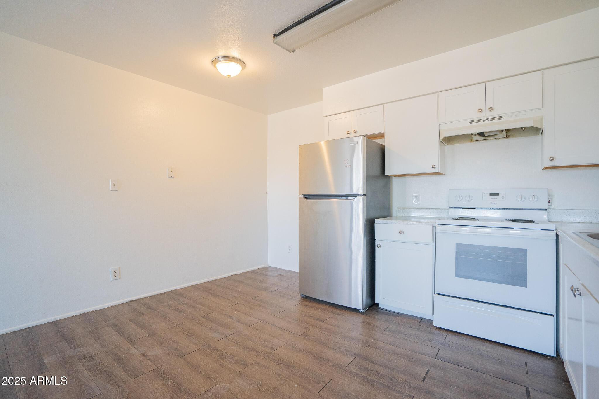 1703 West Mountain View Road, Unit 15 Phoenix, AZ 85021 - Photo 7 of 11 a kitchen with a refrigerator and white cabinets