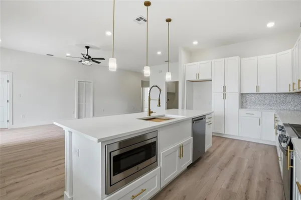 a kitchen with a sink stove and white cabinets