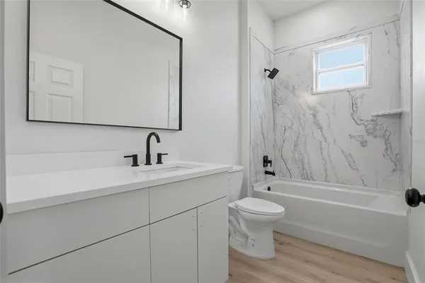a bathroom with a toilet a sink and mirror