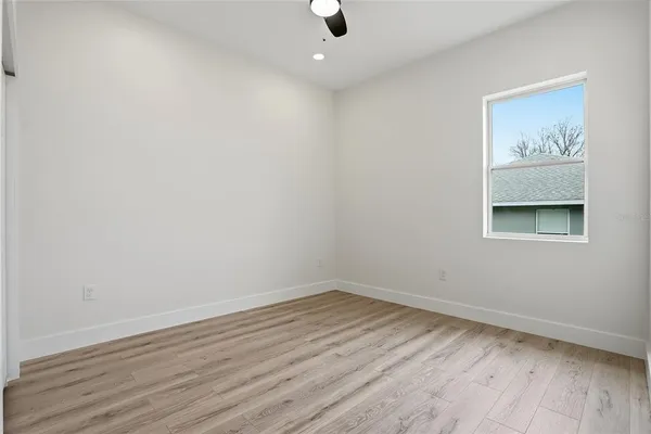 a view of an empty room with wooden floor