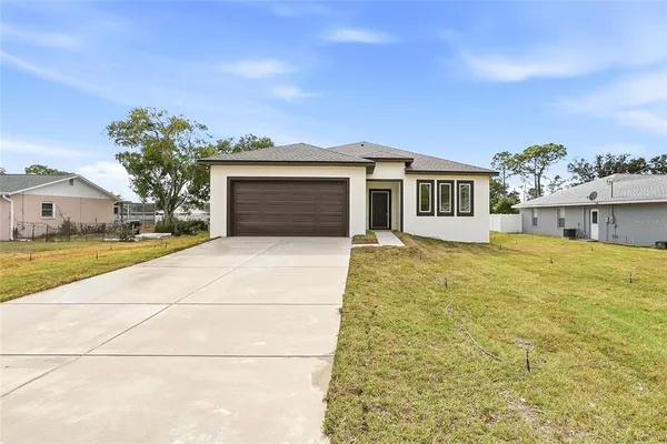 a front view of a house with a yard and garage