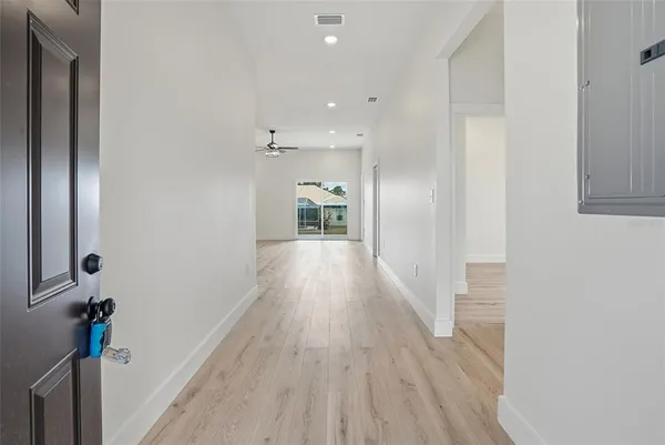 a view of a hallway with wooden floor and staircase