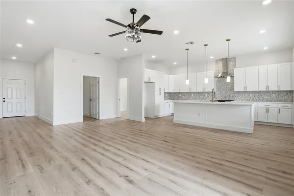 an open kitchen with kitchen island white cabinets and stainless steel appliances