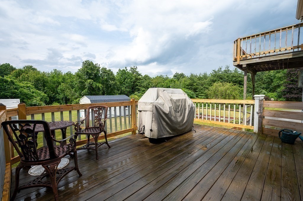 65 Lancaster Road Shirley, MA 01464 - Photo 14 of 42 a view of a roof deck with table and chairs with wooden floor and fence