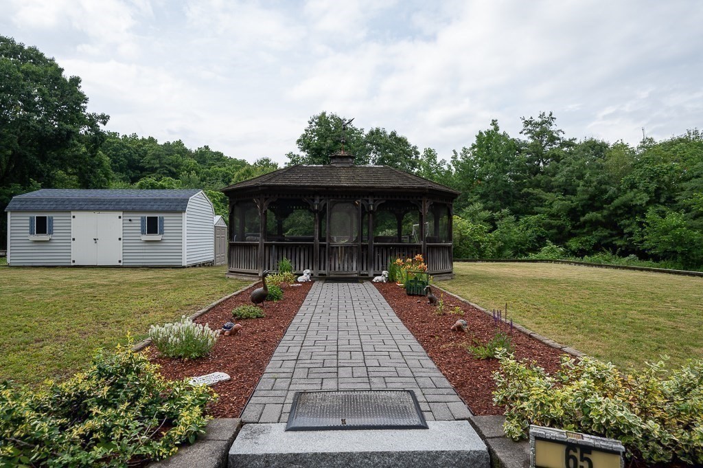 65 Lancaster Road Shirley, MA 01464 - Photo 30 of 42 a front view of house with yard and trees in the background