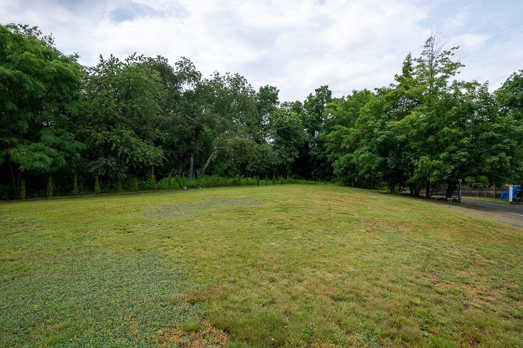 65 Lancaster Road Shirley, MA 01464 - Photo 7 of 42 a view of a field with trees in the background