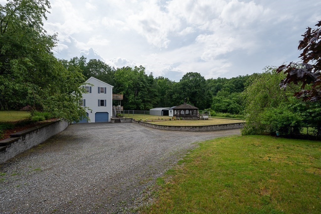 65 Lancaster Road Shirley, MA 01464 - Photo 9 of 42 a view of a swimming pool with a yard and large trees