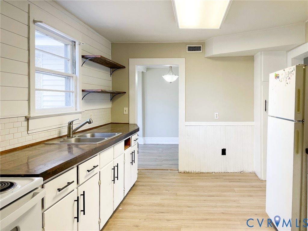 1016 Court Street Victoria, VA 23974 - Photo 10 of 29 a kitchen with granite countertop a sink and a stove next to a window