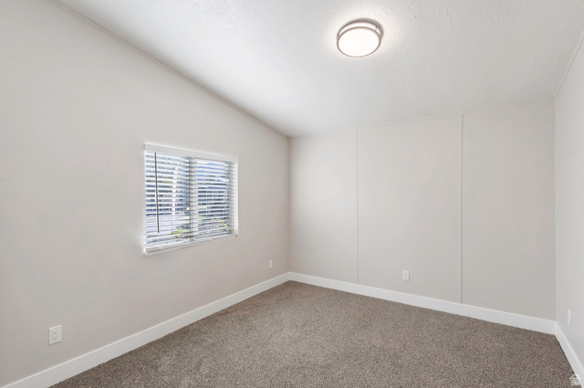 96 Barrington Way Layton, UT 84041 - Photo 8 of 28 Empty room with vaulted ceiling and carpet