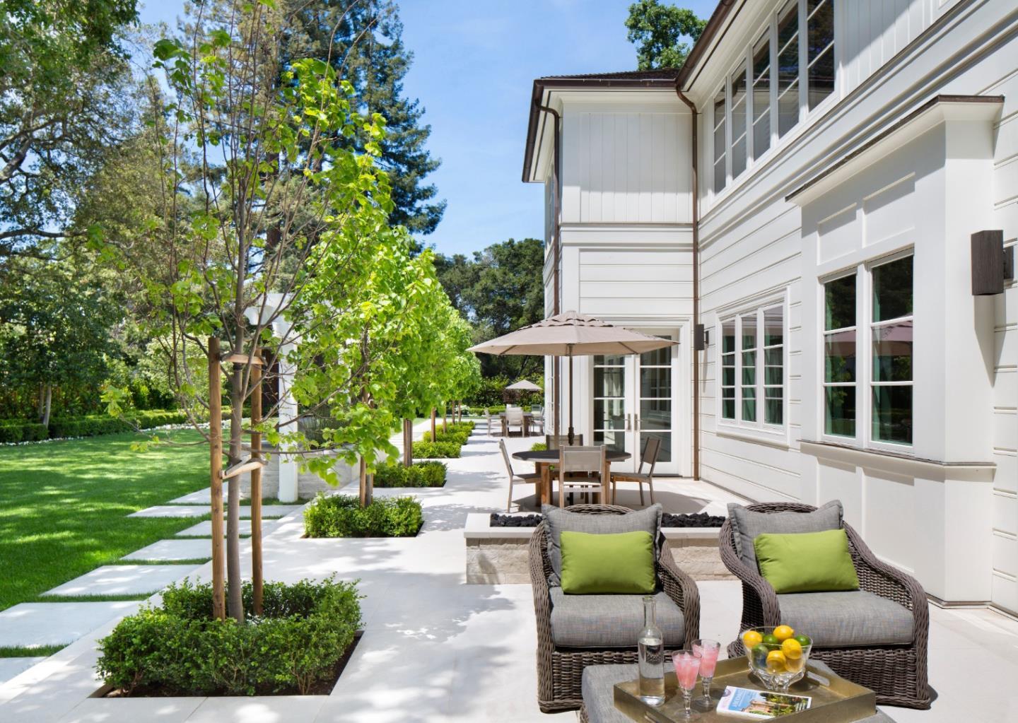 138 Almendral Avenue Atherton, CA 94027 - Photo 41 of 44 a view of a patio with couches table and chairs under an umbrella with a fire pit