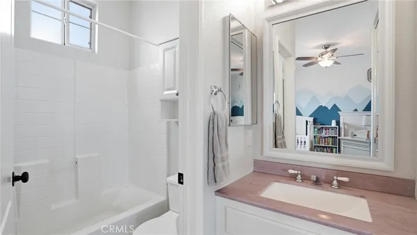 a bathroom with a granite countertop sink a mirror and a bathtub
