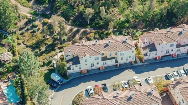 an aerial view of a house with large trees