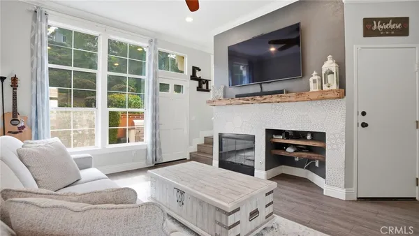 a living room with furniture a flat screen tv and a fireplace