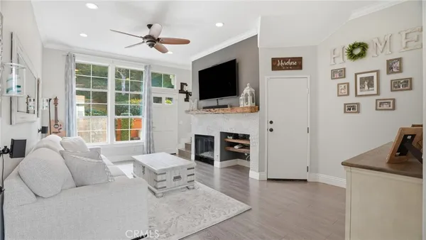 a living room with furniture a flat screen tv and a fireplace