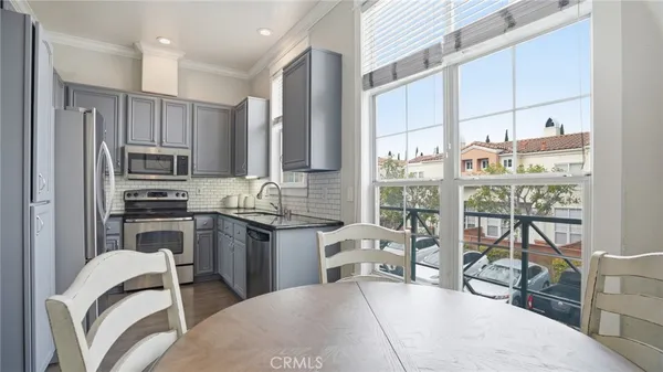 a kitchen with stainless steel appliances granite countertop a stove top oven a sink and a refrigerator