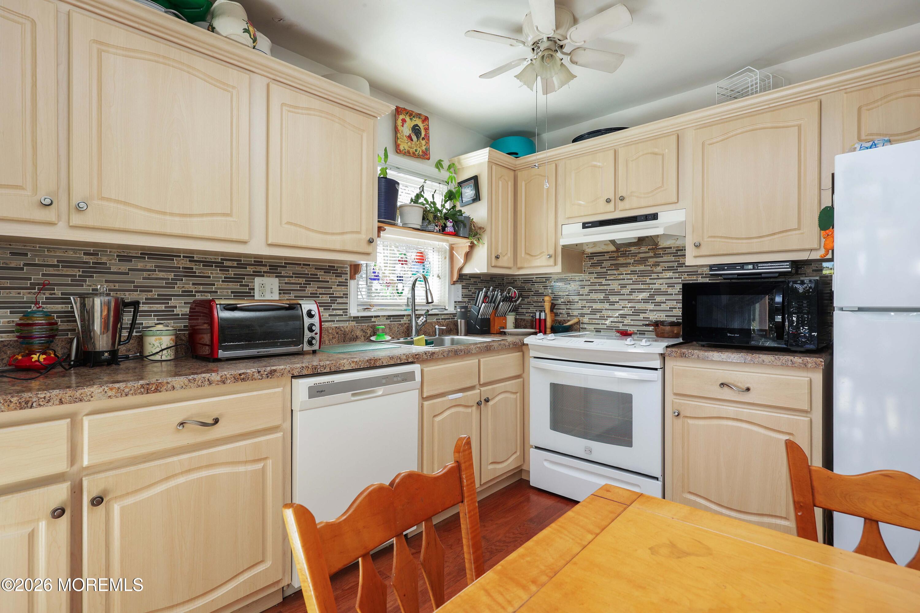 74 Sheffield Place Southampton, NJ 08088 - Photo 9 of 20 a kitchen with stainless steel appliances granite countertop a sink a stove a refrigerator cabinets and chairs