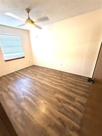 a view of a room with wooden floor and a ceiling fan