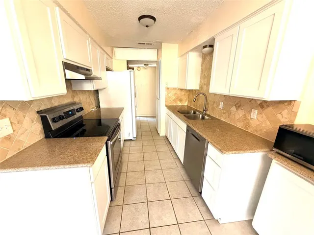 a kitchen with a sink a stove and a refrigerator