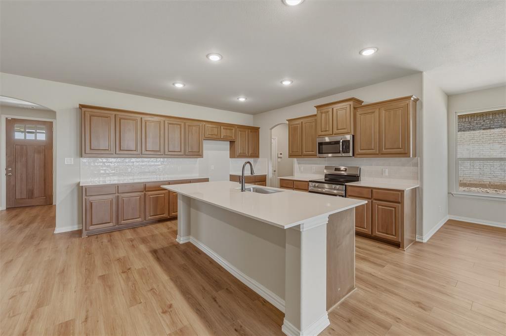 1209 Colca Drive Springtown, TX 76082 - Photo 9 of 24 Open-concept kitchen featuring an expansive center island with an integrated sink, wood-finish flooring, and recessed lighting
