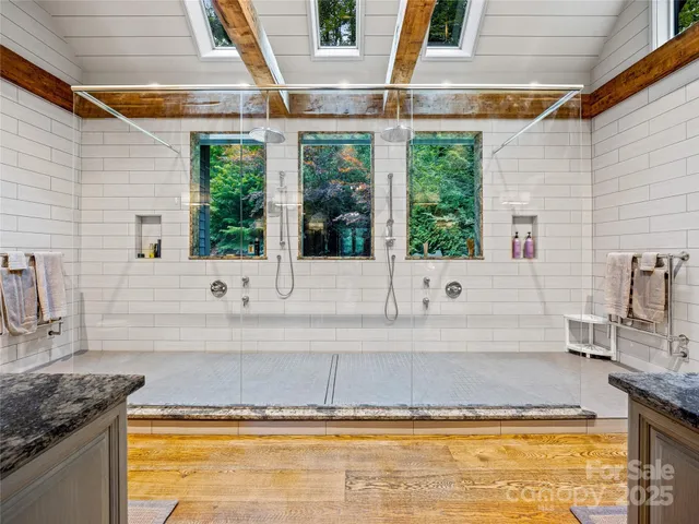 a spacious en suite bathroom with a granite countertop tub and glass windows