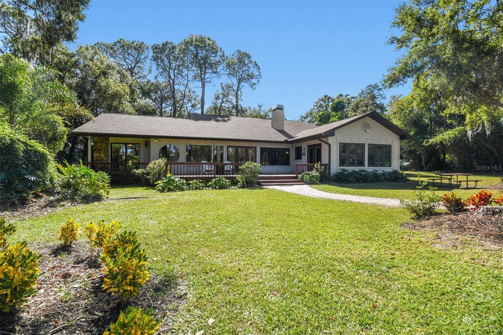 8011 North Mobley Road Odessa, FL 33556 - Photo 68 of 86 a front view of a house with swimming pool and porch with furniture