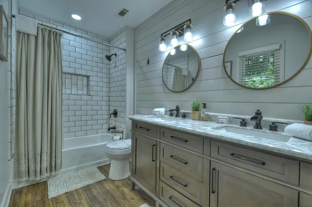 a bathroom with a granite countertop sink mirror and toilet