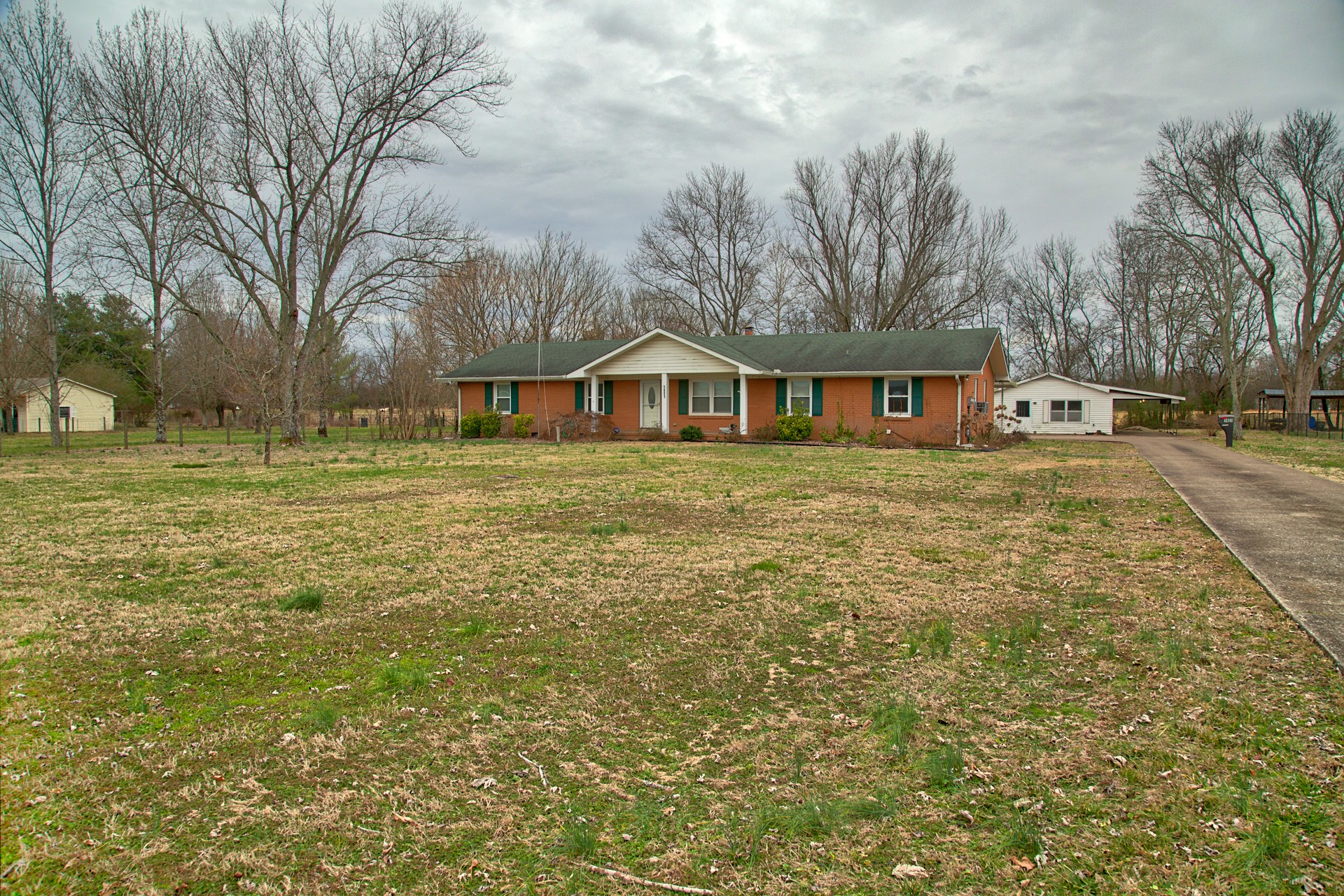 a front view of residential houses with yard and trees
