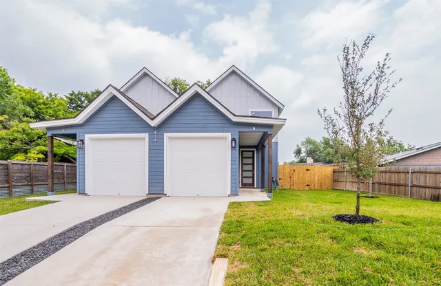 a front view of a house with a yard and trees