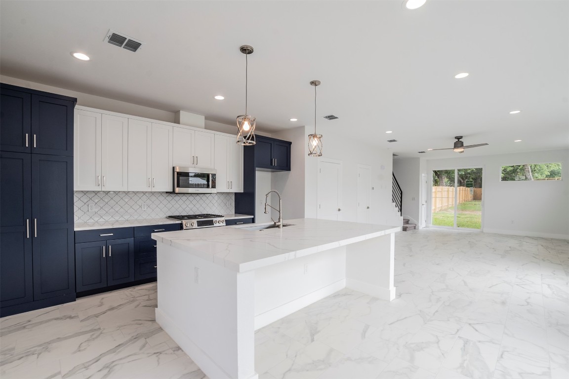 616 West Dittmar Road Austin, TX 78745 - Photo 6 of 37 a large white kitchen with a stove a sink a refrigerator and a center island