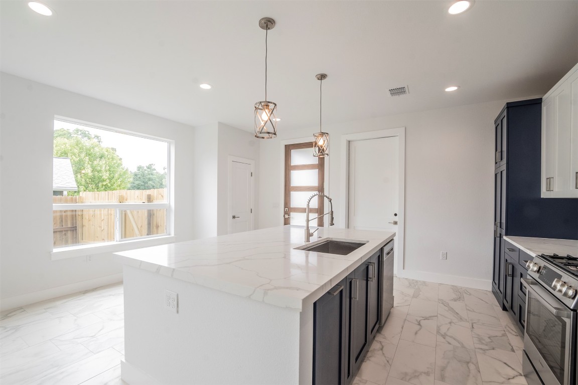 616 West Dittmar Road Austin, TX 78745 - Photo 8 of 37 a kitchen with stainless steel appliances granite countertop a sink a stove and a wooden floor