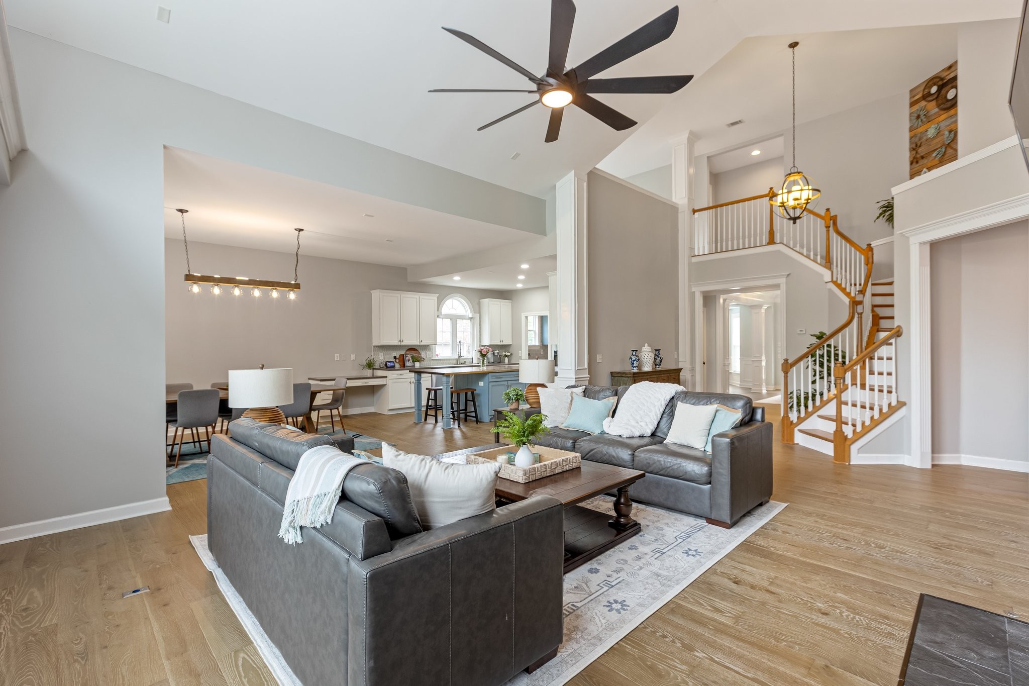5048 Abington Ridge Lane Franklin, TN 37067 - Photo 14 of 64 a living room with couches and a dining table with wooden floor