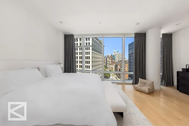 a spacious bedroom with a bed and a large window