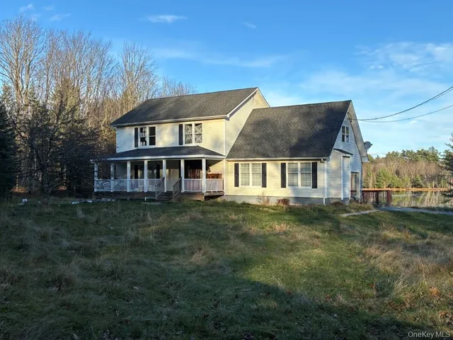 a aerial view of a house next to a big yard and large trees