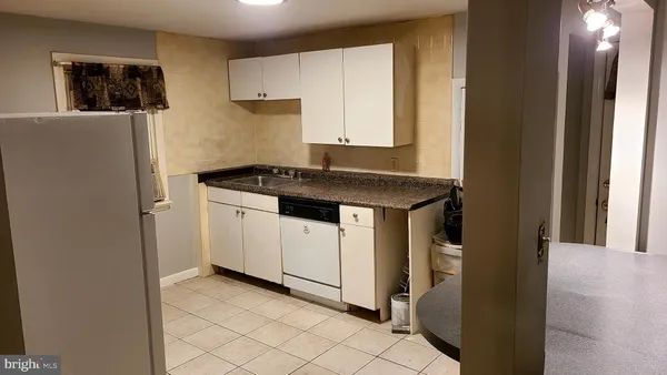 a white refrigerator freezer and a stove sitting inside of a kitchen