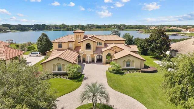 an aerial view of a house with a yard and lake view