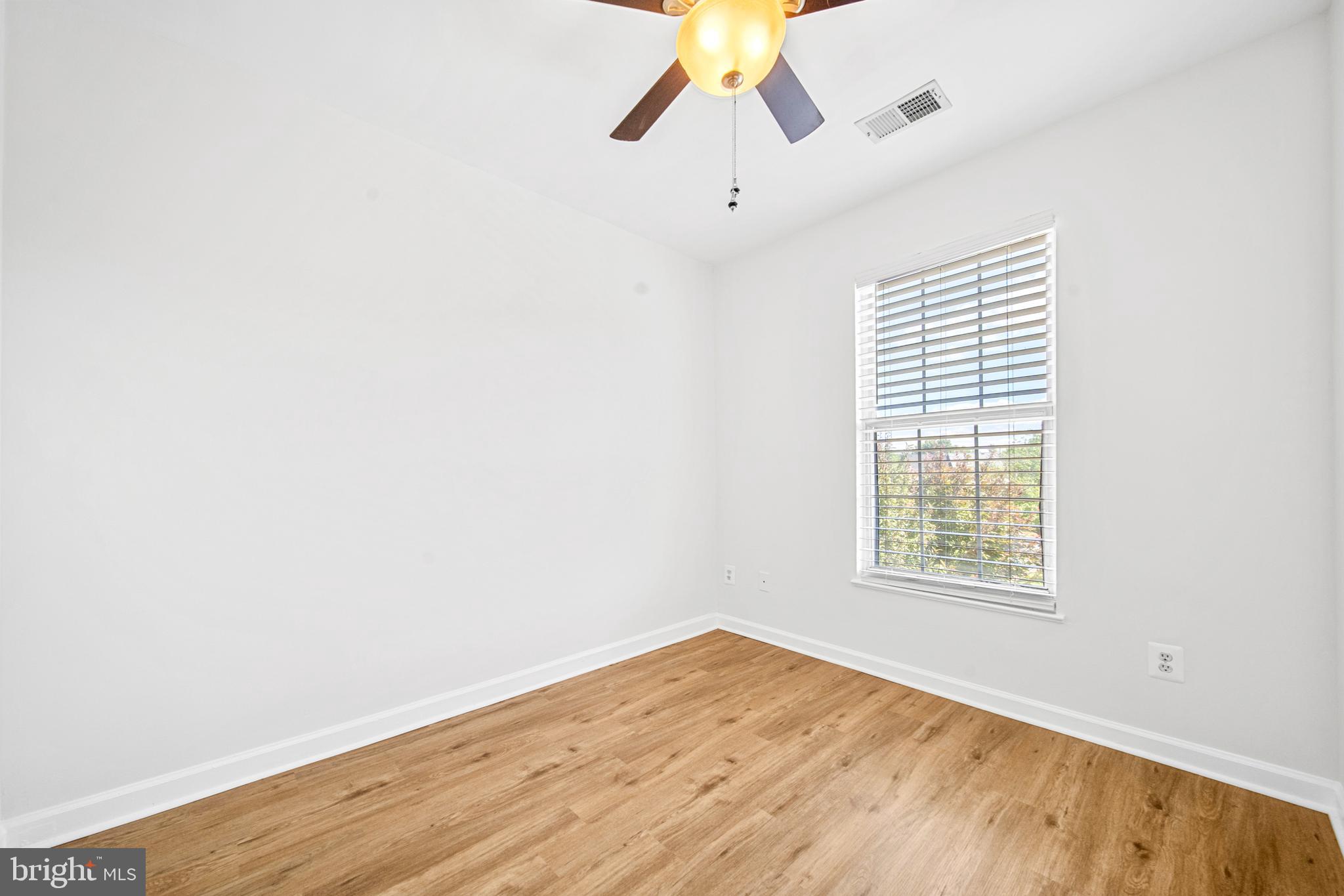 8596 Cold Harbor Loop Manassas, VA 20111 - Photo 29 of 52 an empty room with wooden floor ceiling fan and windows