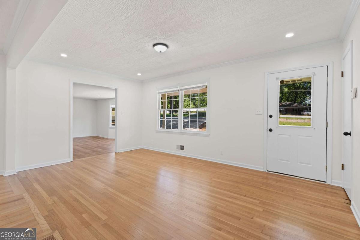 865 Old Tucker Road Stone Mountain, GA 30087 - Photo 10 of 57 a view of an empty room with window and wooden floor